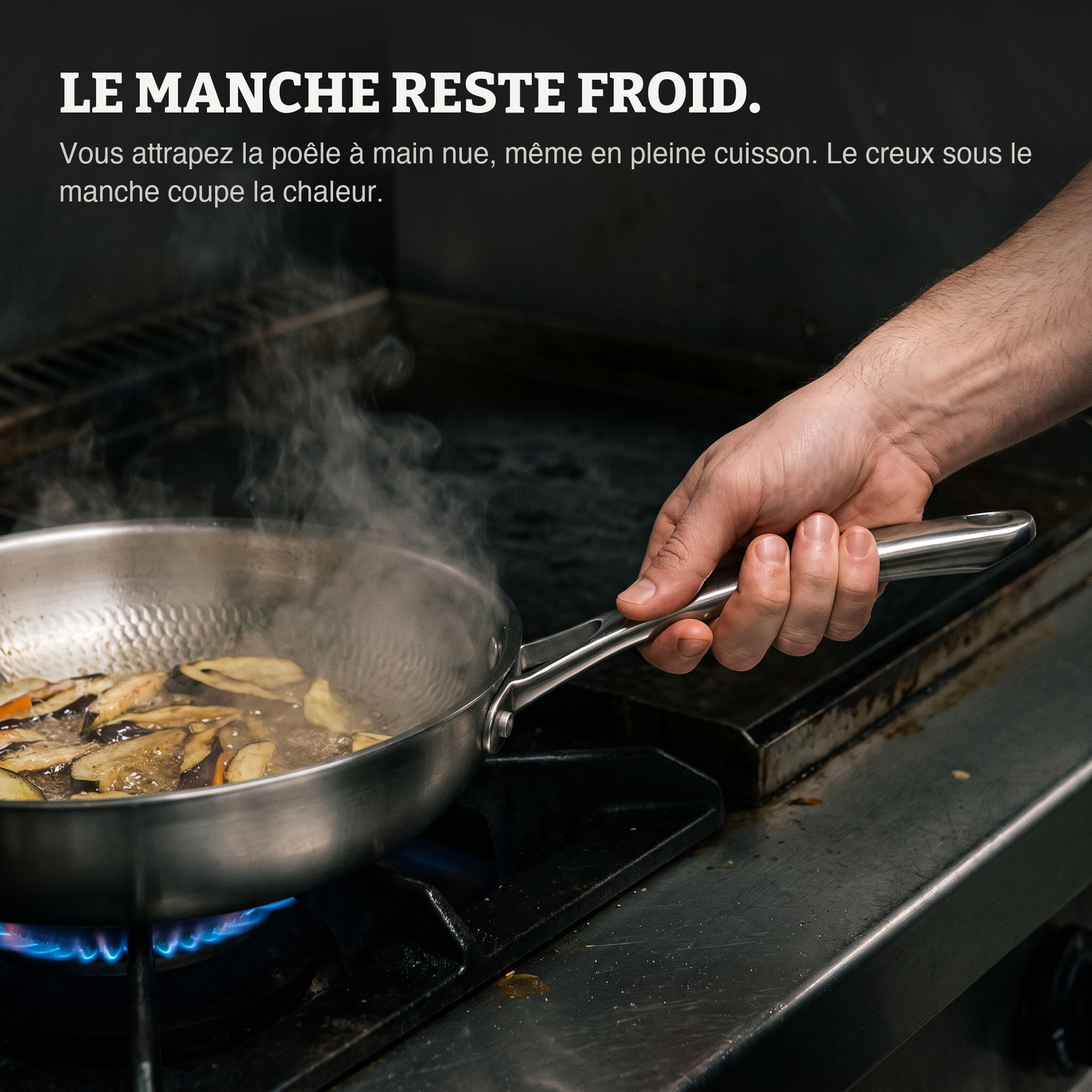 Une main nue tient le manche en acier pendant la cuisson